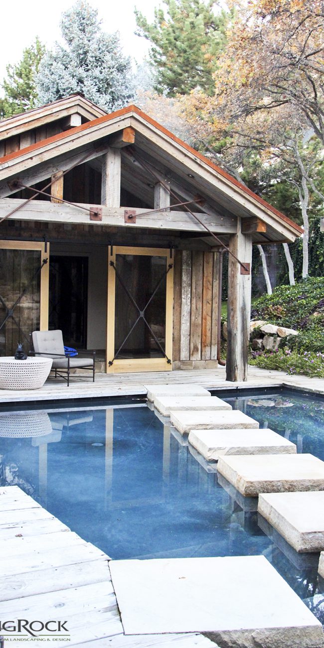 A pool patio doesn't have to be stone or pavers. Create a landscape design that matches your aesthetic such as a wood deck that wraps your backyard pool.