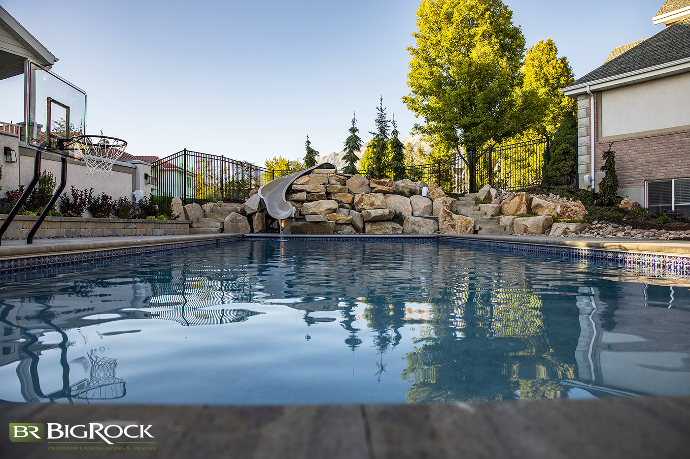 Your backyard pool doesn't have to be boring. Create design interest with natural rock walls and slide installation.
