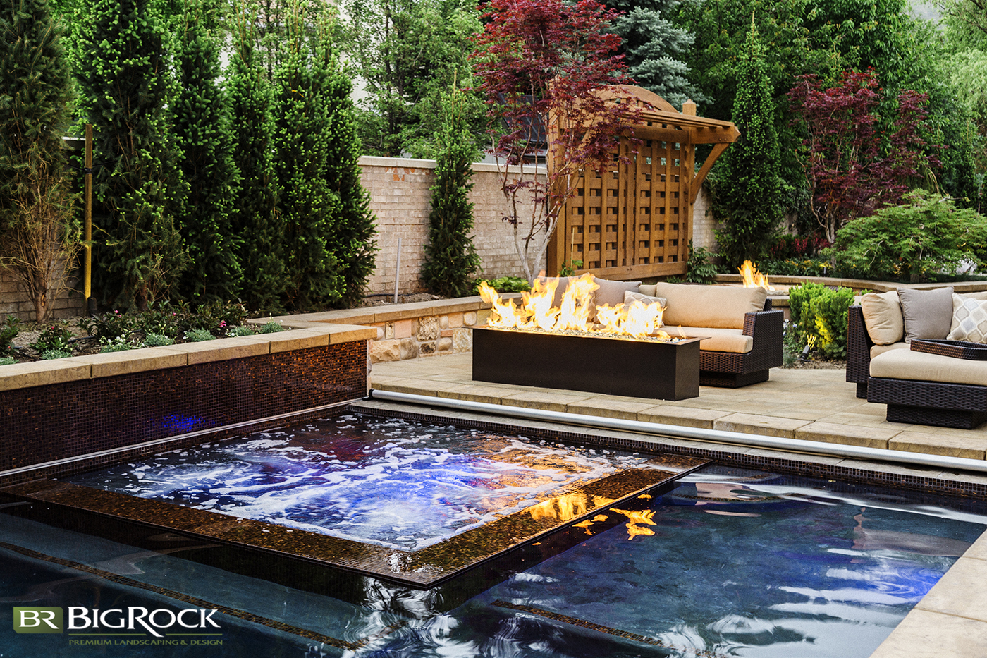 Luxury backyard pool layouts such as an integrated hot tub and garden bed lined pools create a unique and beautiful landscaping design.