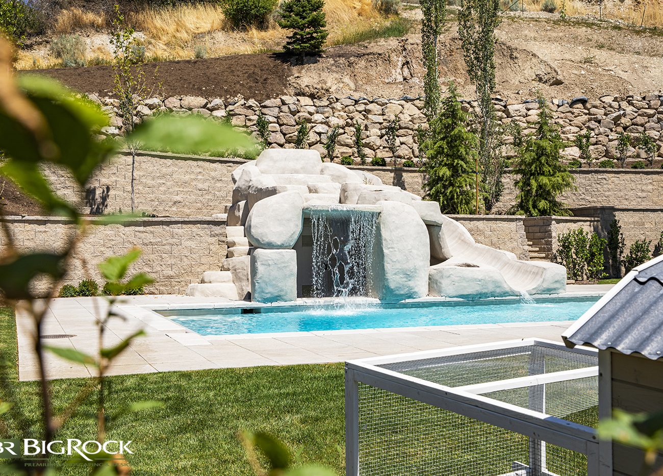 Step up your backyard pool with a flowing water feature built-in to the landscape.
