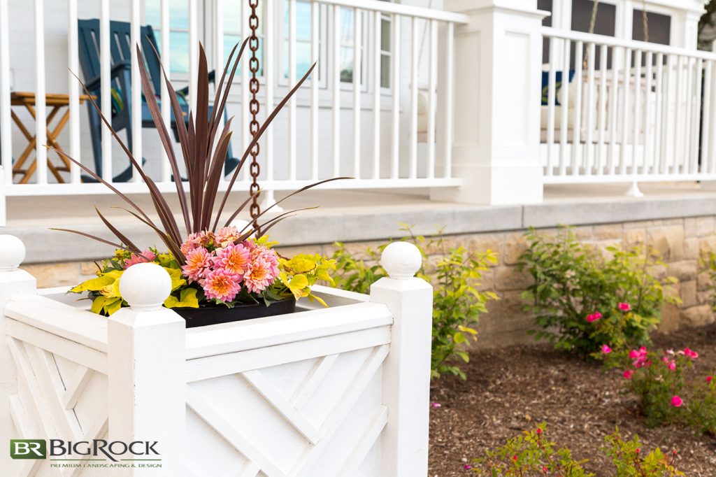 Small garden boxes against front yard walkways make it easy to change out landscaping plants with the season and to add pops of color.