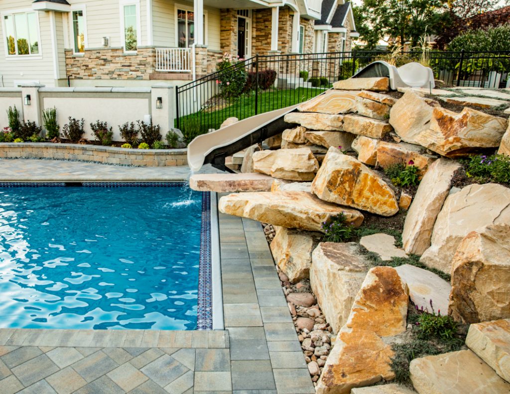A water slide and Browns Canyon sandstone jumping ledges and rocks are intermixed with natural plants to create an area that is beautiful to look at and endlessly entertaining.