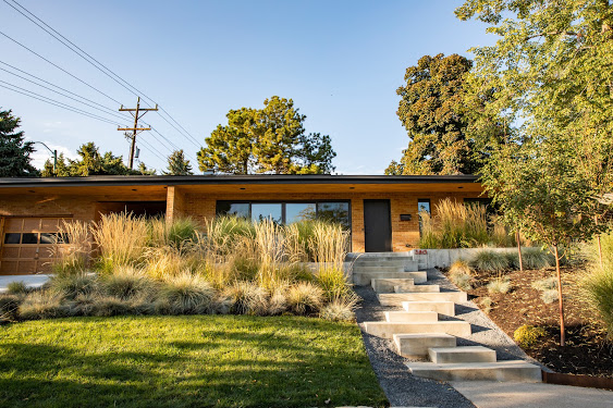 The staggered walkway and natural grasses give this front of house landscaping a wild and free feeling.
