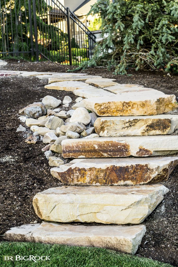 Using natural elements like these stone steps can help add interest and transition a yard between green grass and more water conscious elements.