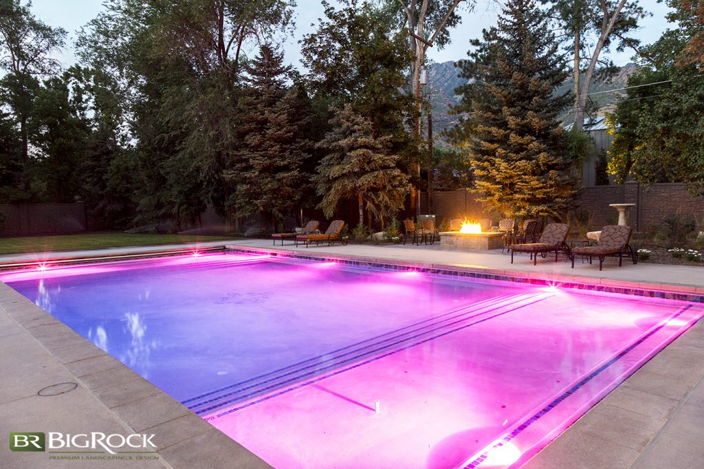 In this picture, the pool area is well lit from within and the firepit gives off a nice, warm glow