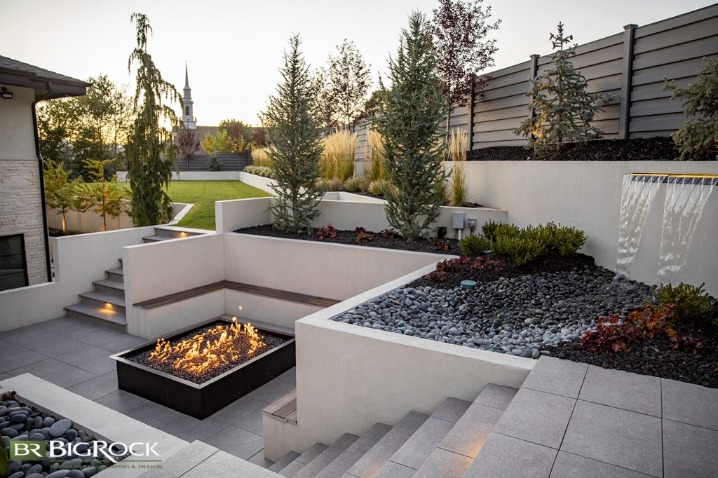Surrounded by built-in seating, this fireplace takes center stage. Its sturdy shape and black frame lend weight and a flair of drama to spice up this modern backyard