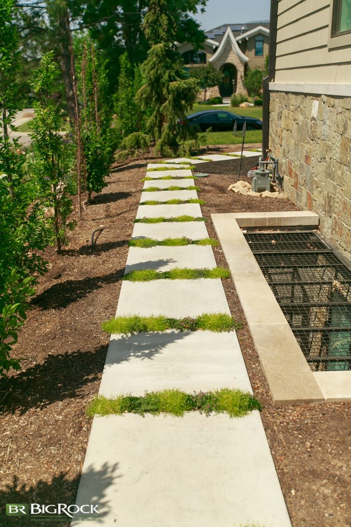 We added ground cover between the pavers, complimentary shrubs in the planters, and neutral, modern colors throughout the design
