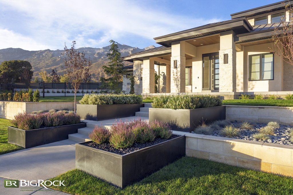 This large front yard is broken up with symmetrical hardscape planters in various materials