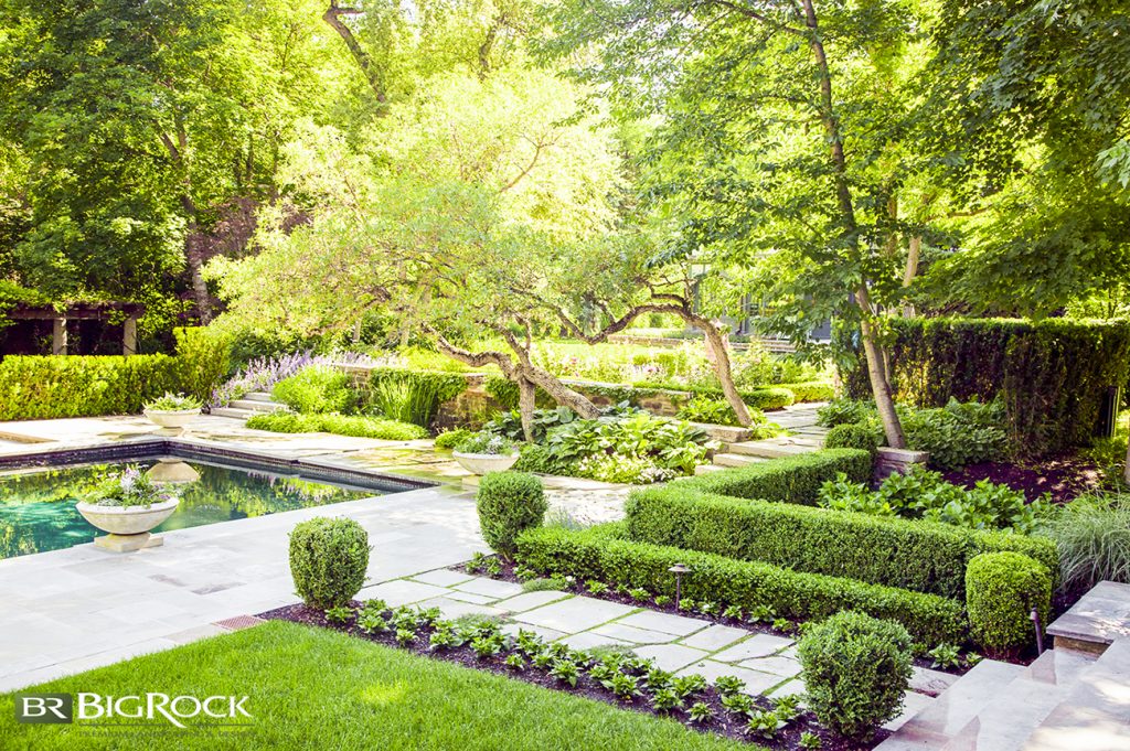 The natural stone pavers of this formal garden path add some visual interest to the uniform space.