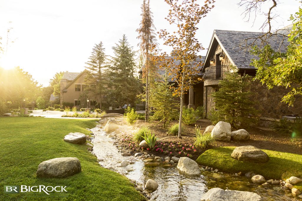 The stream and rock placement give the feel that they have always been in this yard.