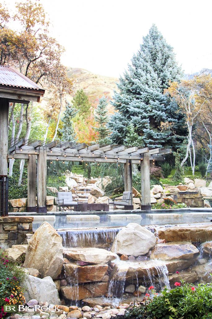 Stepping into this backyard makes you wonder if you took a wrong turn and ended up in the mountains. We used stones and natural elements to create this rustic waterfall and complete the look of this yard