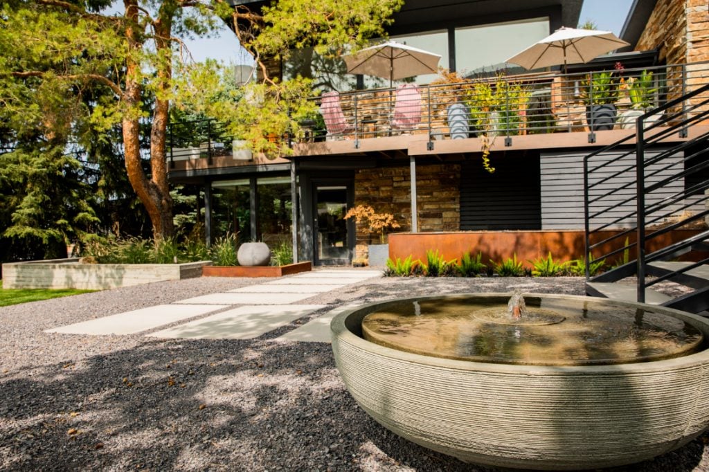 This is a great example of xeriscaping in disguise. Because there are so many potted plants on the deck along with the mature trees that already existed in the space, it’s easy to forget the rock and paver pathway below.