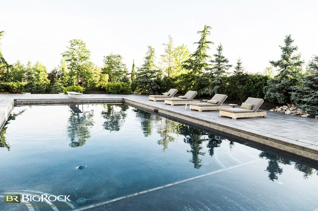 This clever use of a variety of evergreens surrounding the homeowner’s backyard pool juxtaposes a bit of the untamed with plenty of luxury, offering the year-round privacy we all crave in our outdoor spaces when living in close quarters.