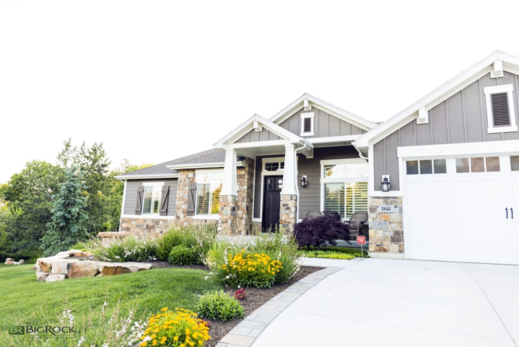 Using rock retaining walls can maximize a grand entrance to your home, especially if you live on a property with a sloped front yard. Adding boulders that match the rock exterior helps bring the whole property together and creates level spaces for added landscaping, like shrubs and flowers.