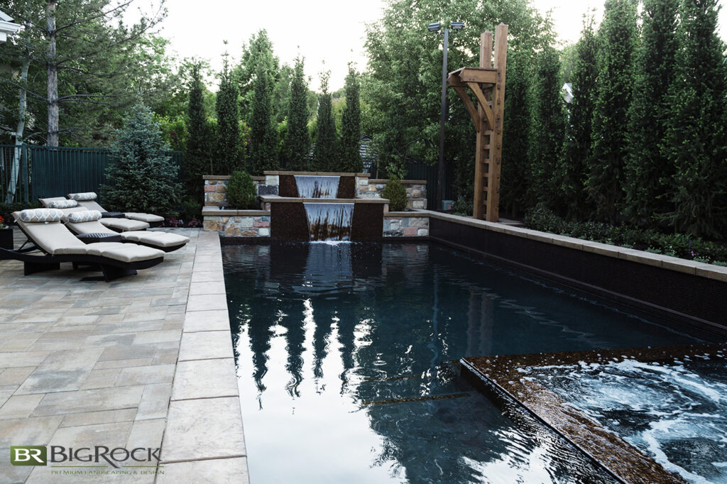 What’s better than one waterfall in your custom pool? Two waterfalls into your custom pool. We loved designing this double waterfall feature, but don’t forget the in-pool hot tub and the custom jumping platform, which add more variety to the space.