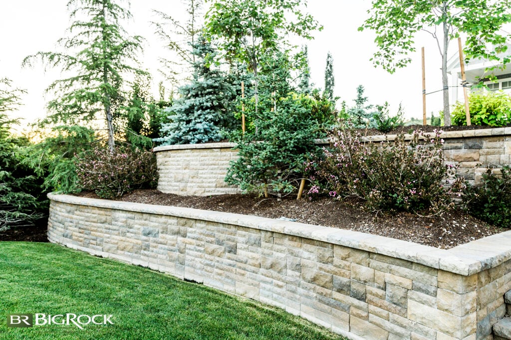 For some yards, it’s easier to add a second retaining wall, not only because of a steep slope but also because it provides extra layers for added visual interest. Note how the landscaping and walls highlight each other—where the upper wall curves out, there isn’t any landscaping, but it is framed by two bushes to balance it.