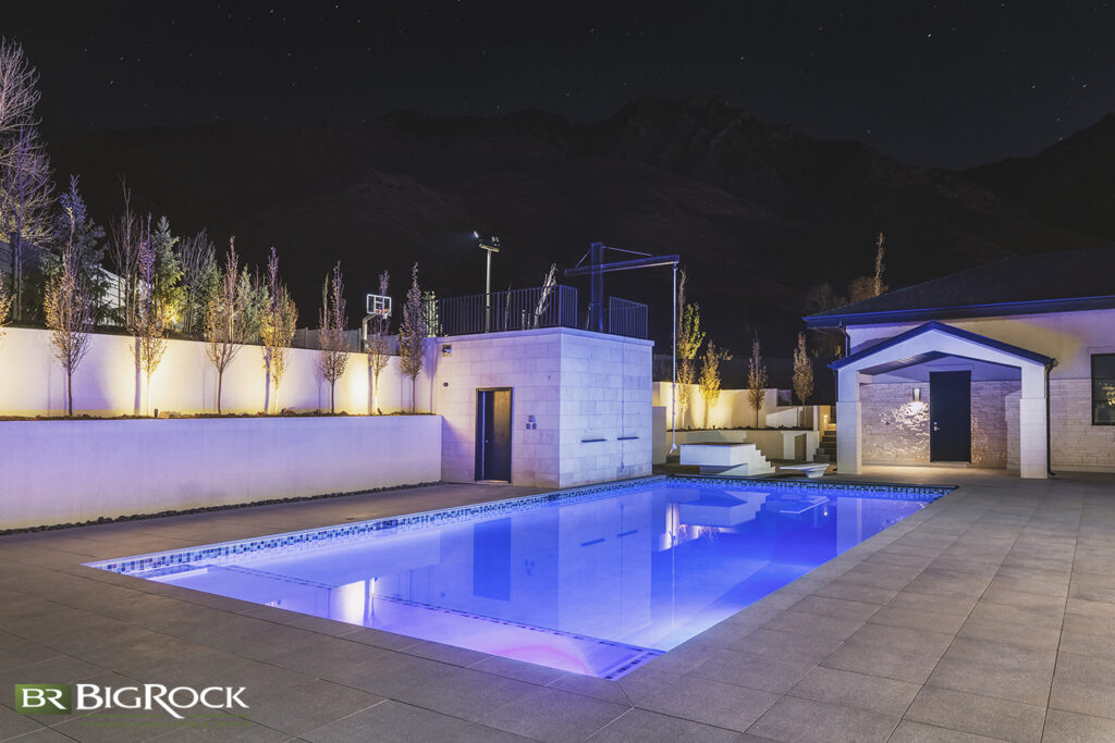 Your hardscape is a visual feature, but it can also be the focus of the fun! In this backyard pool, the hardscape includes the poolhouse, with a rope swing, a double retaining wall, and a couple of custom water fountains.