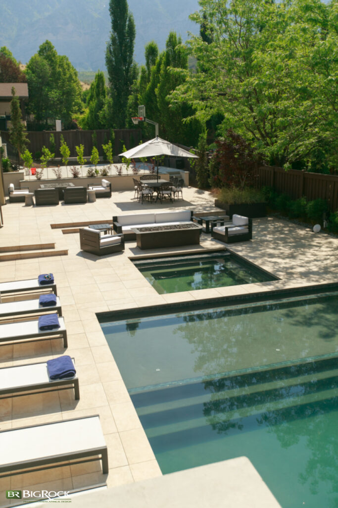 When you think of installing a pool, you have to think about the area around it, and this project features one of the best layouts we’ve designed for pool hardscaping. Note the multiple entertainment spots, including a dining area.