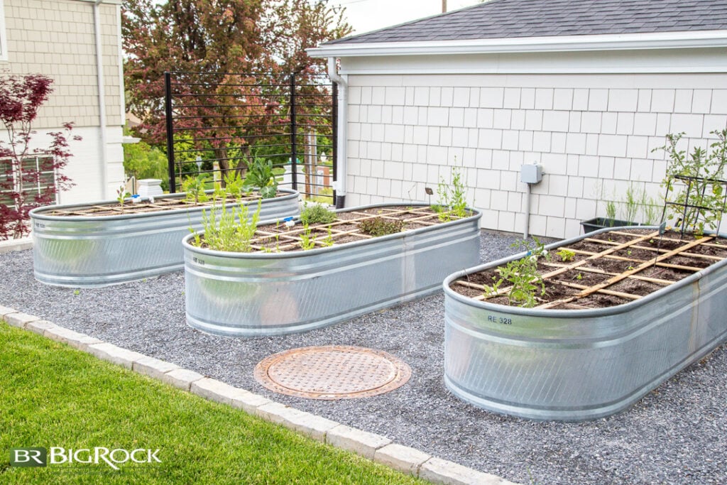 A segmented section of a backyard using large raised garden bed to add to this small yard landscaping design.